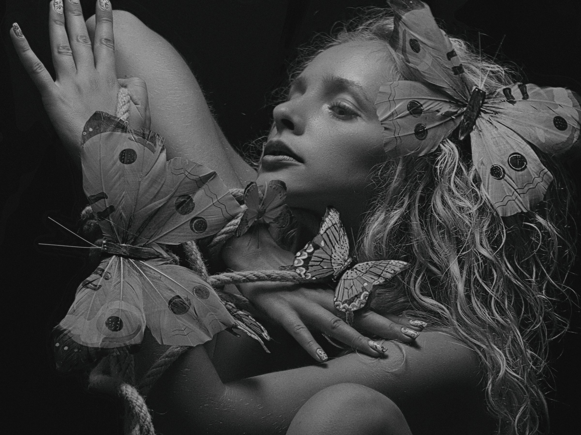 Black and White Photo of a Woman Posing with Butterflies